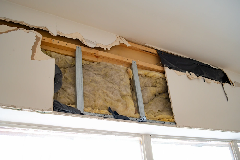 torn wall and exposed insulation